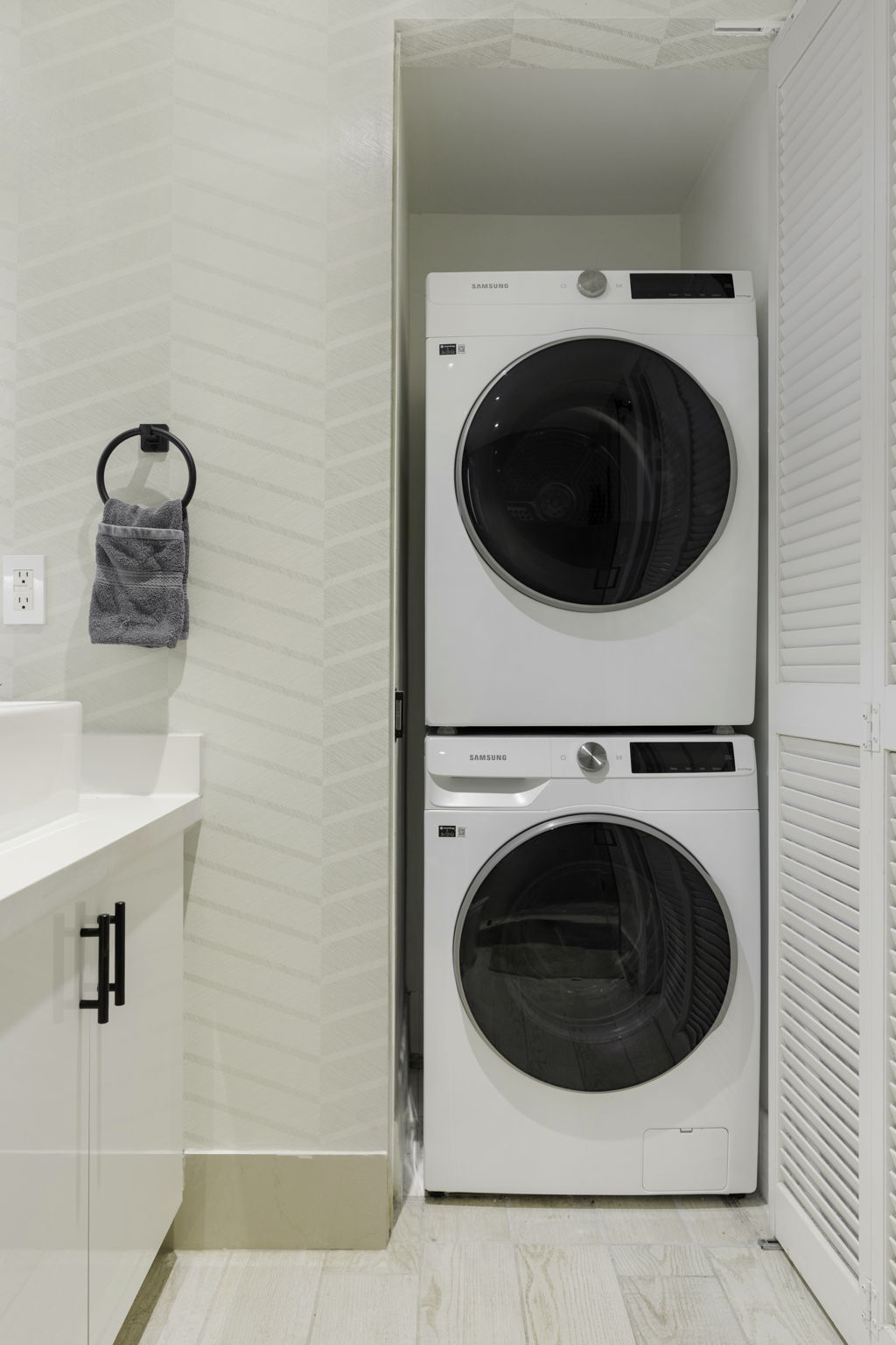 In-unit stacked washer and dryer beside the bathroom